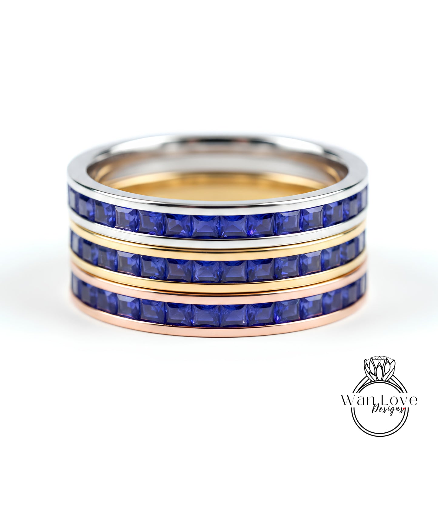 A ring with three concentric bands, each with a blue gemstone. The top and bottom bands are gold, while the middle band is silver. The gemstones are blue, and the ring appears to be made of metal.