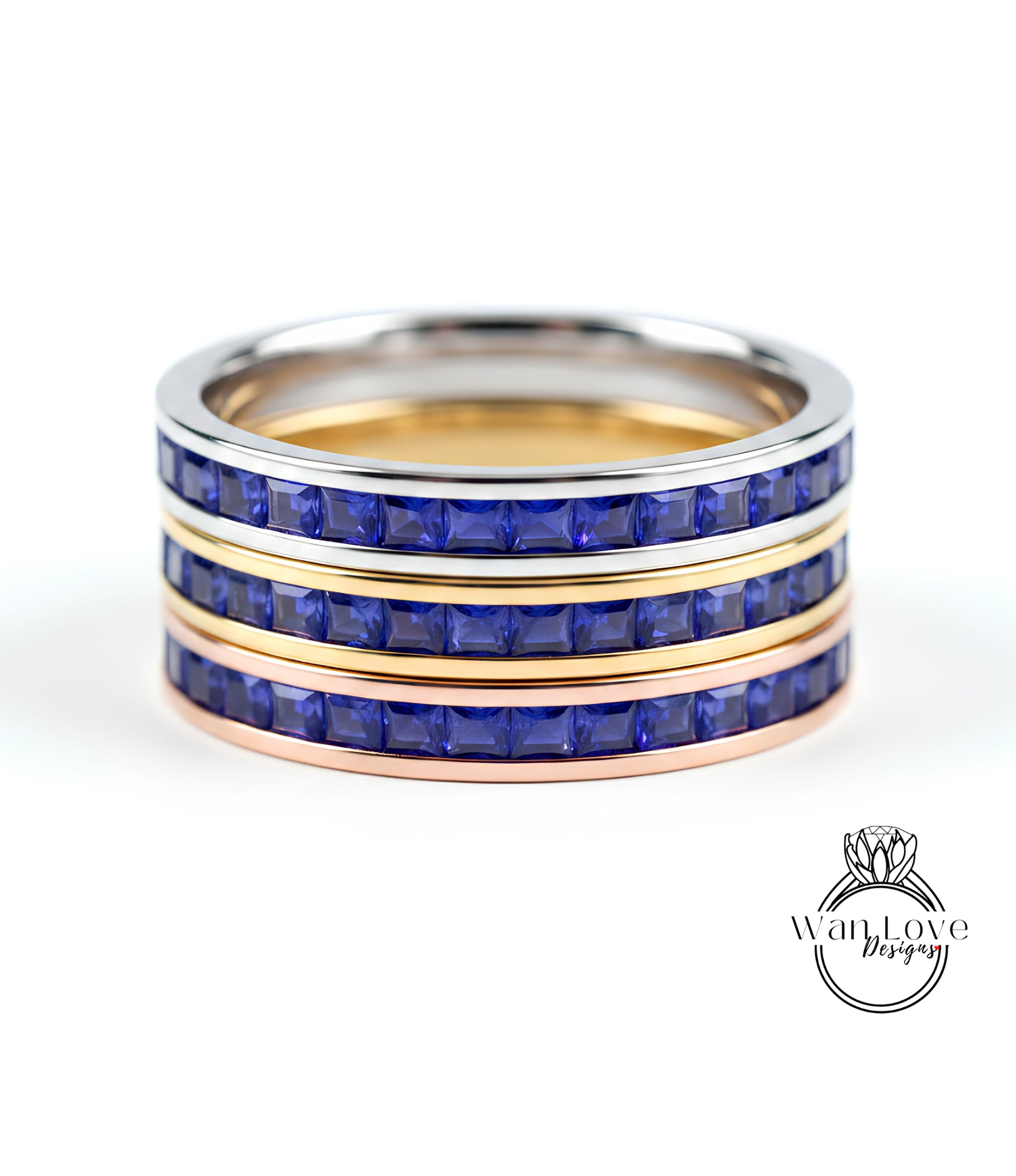A ring with three concentric bands, each with a blue gemstone. The top and bottom bands are gold, while the middle band is silver. The gemstones are blue, and the ring appears to be made of metal.