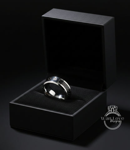 A silver ring is displayed in a black jewelry box against a dark background.