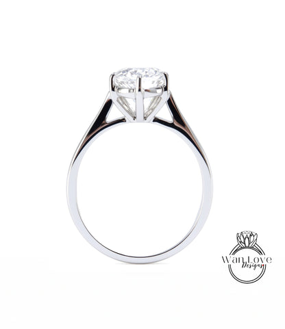A close-up view of a silver engagement ring with a large diamond set in the center.