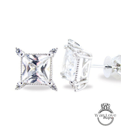 A pair of elegant diamond earrings with a large, clear gemstone set in a silver frame.