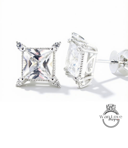 A pair of elegant diamond earrings with a large, clear gemstone set in a silver frame.