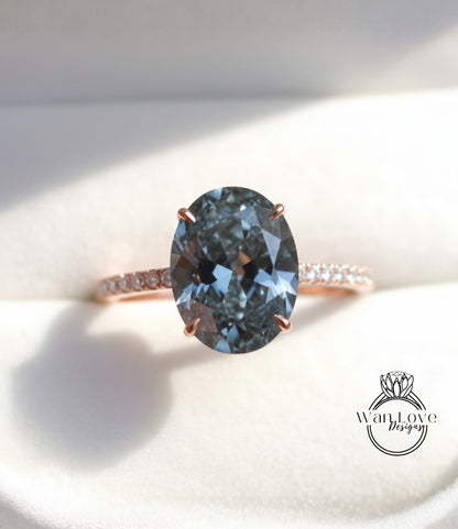 A close-up image of a rose gold ring with a large oval-shaped blue gemstone set in the center.