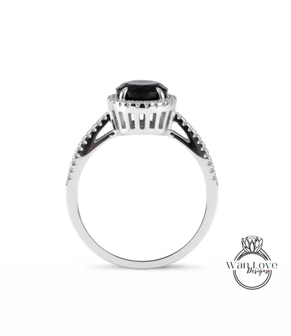 A silver ring with a large black gemstone, possibly a diamond, at the center.
