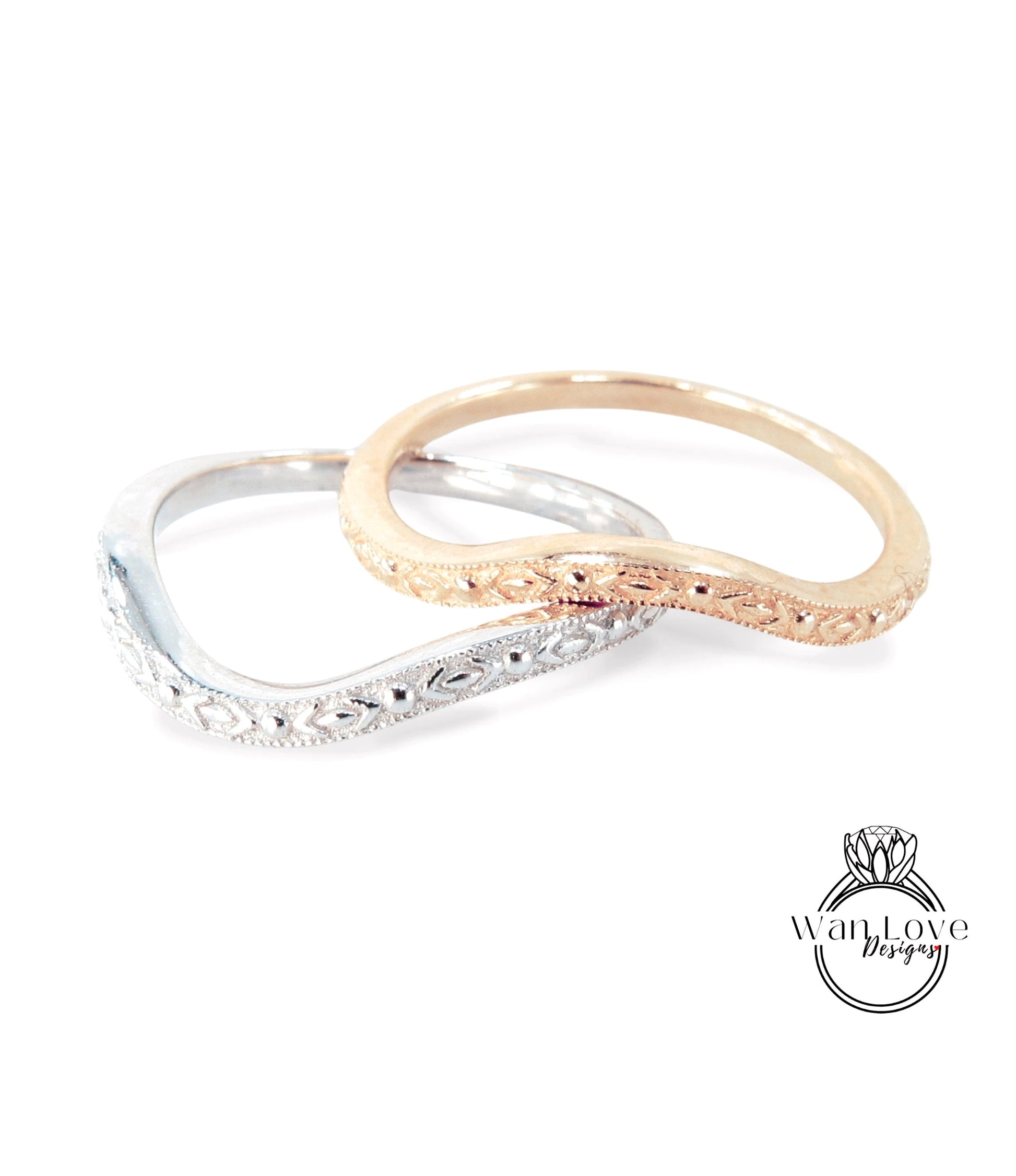 Two ornate rings, one silver and one gold, are displayed together against a white background.