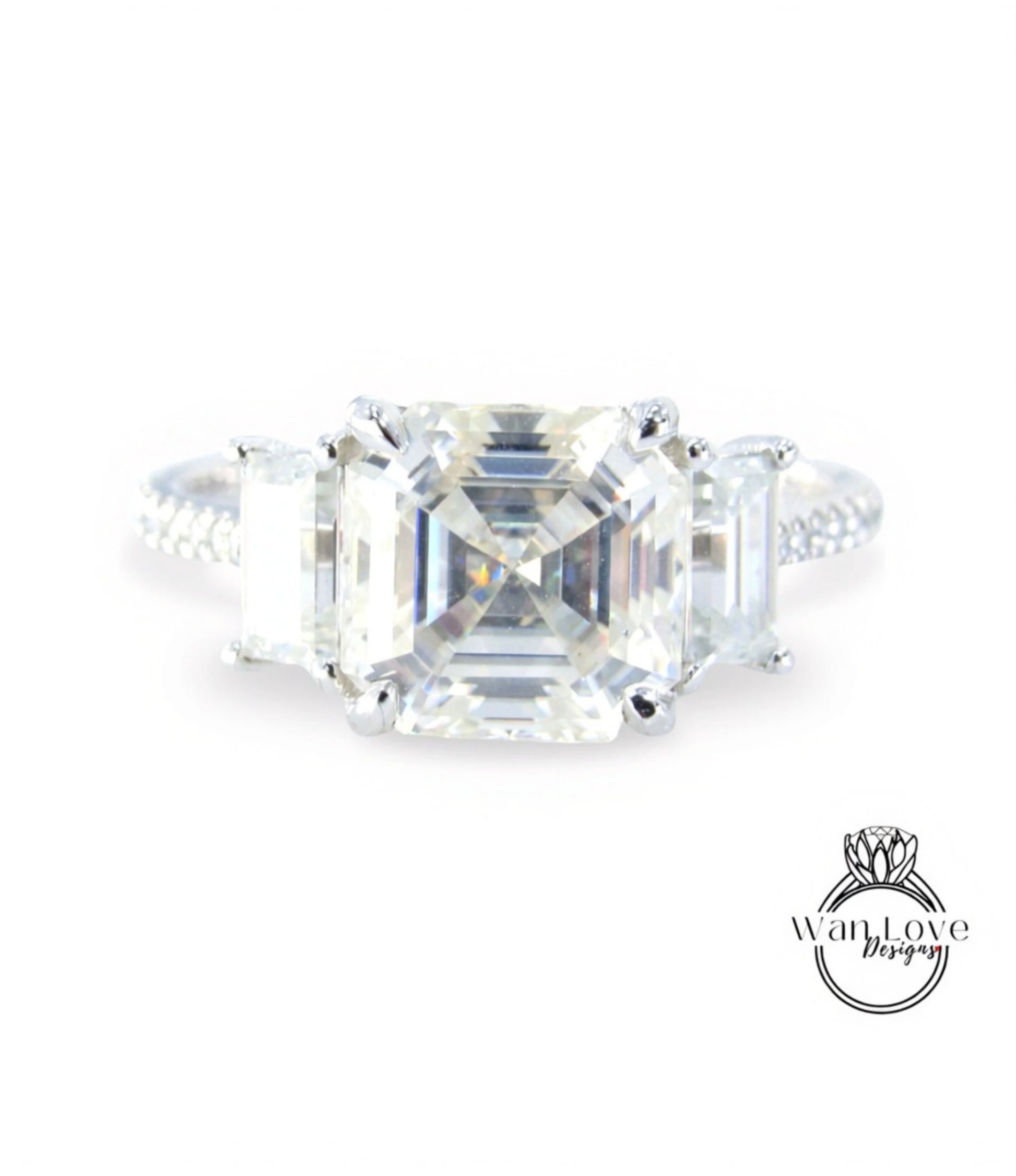 A large, clear gemstone engagement ring with a prominent central diamond surrounded by smaller diamonds.