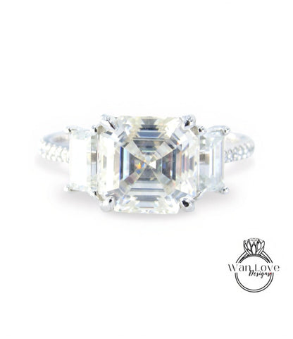 A large, clear gemstone engagement ring with a prominent central diamond surrounded by smaller diamonds.