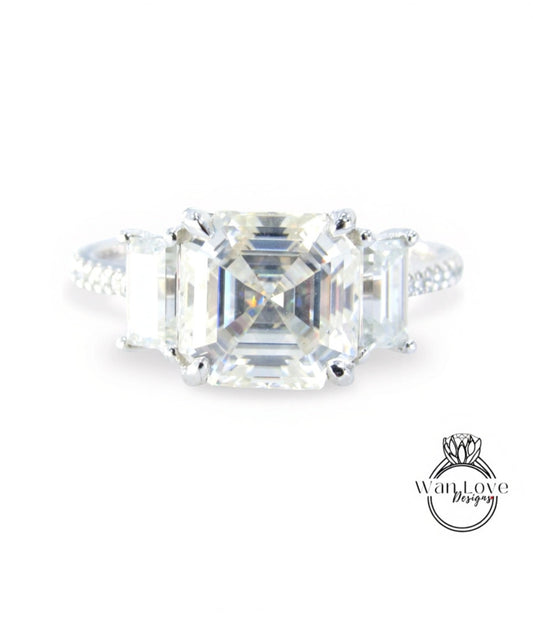 A large, clear gemstone engagement ring with a prominent central diamond surrounded by smaller diamonds.