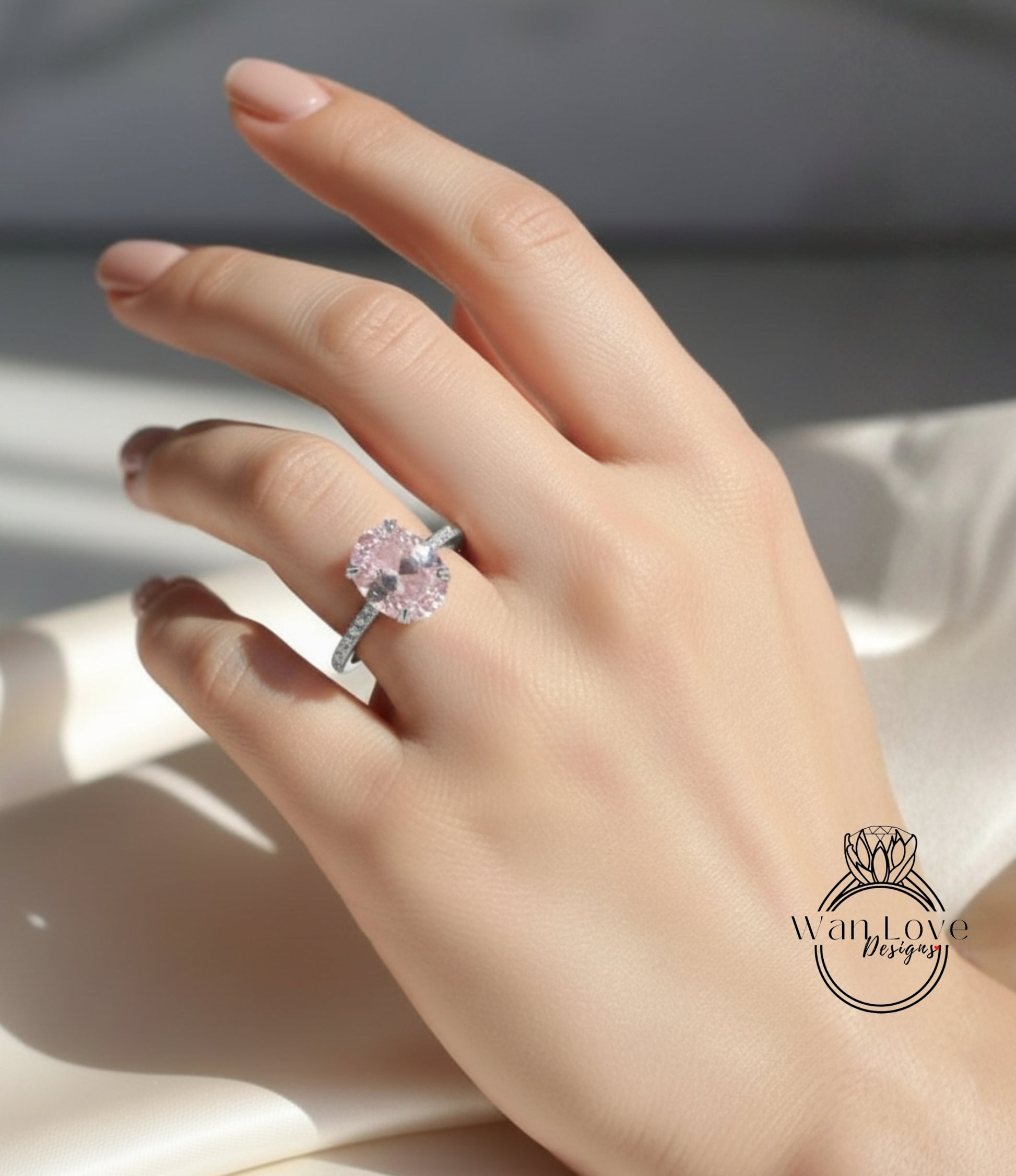 A close-up of a hand wearing a pink diamond engagement ring.