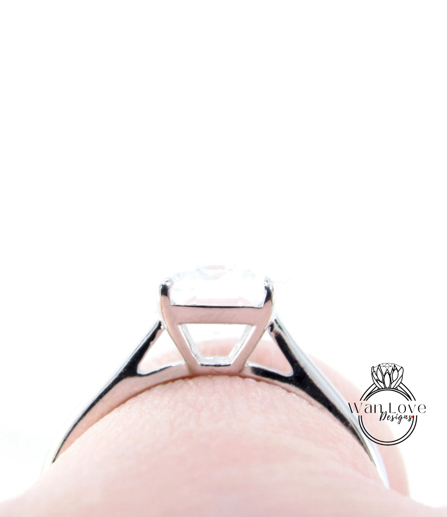 A close-up view of a silver engagement ring with a large diamond set in the center.