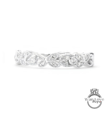 A silver ring with a decorative leaf design and small diamonds.
