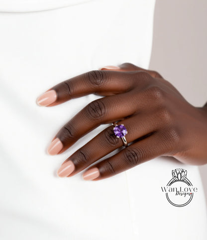 A close-up of a hand wearing a ring with a purple gemstone.
