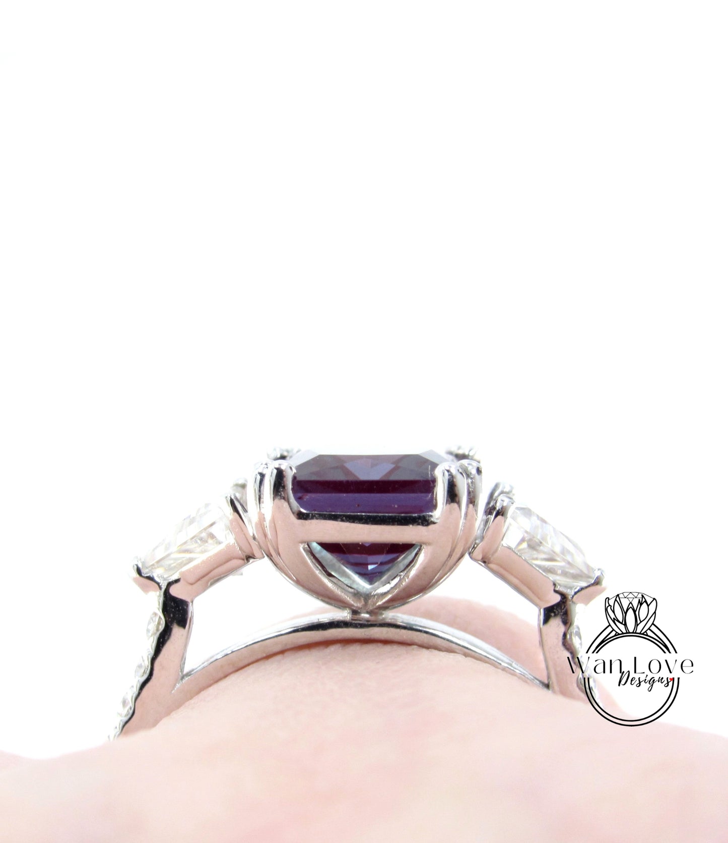 A close-up view of a silver ring with a large purple gemstone, showcasing the intricate design and craftsmanship of the piece.