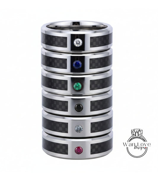 A stack of silver rings with gemstones, including a diamond and four different colored gemstones.