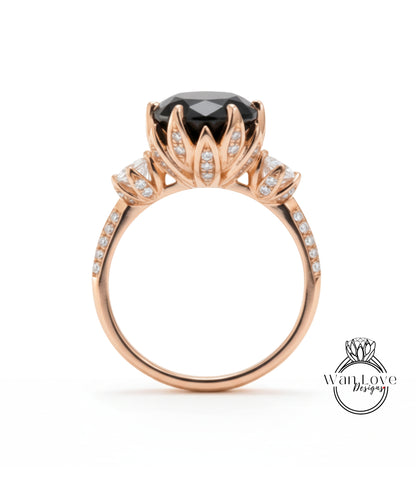 A gold ring with a large black gemstone, likely a diamond, at the center. The ring has a delicate floral design around the gemstone and is adorned with small diamonds.