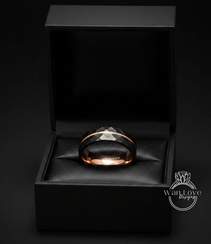 A black jewelry box containing a black and gold ring.