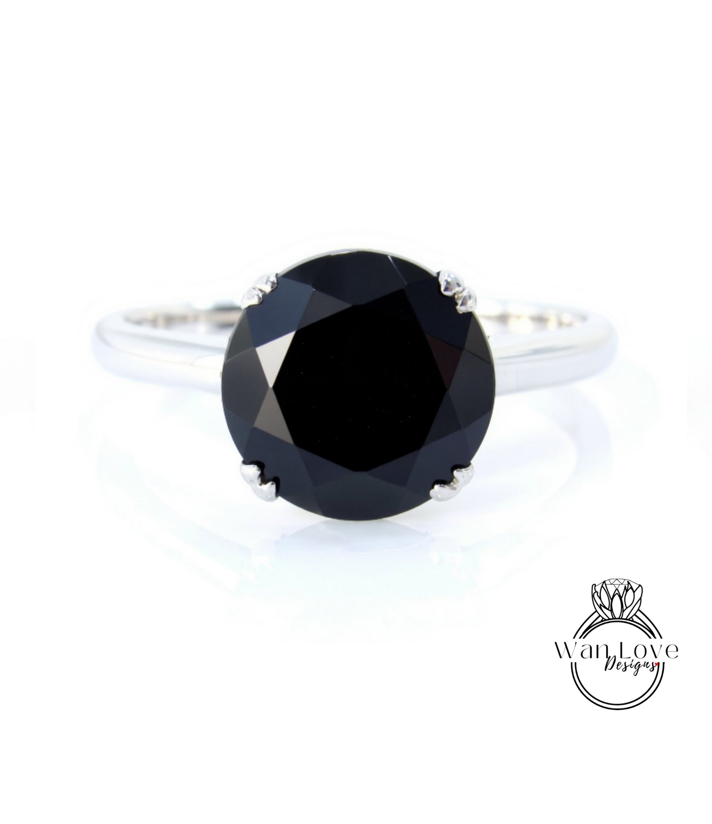 A silver ring with a large, round black diamond as the centerpiece.
