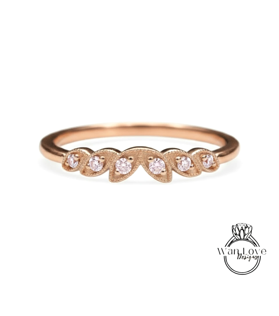 A rose gold ring with a leaf-shaped design and small diamonds set in it.