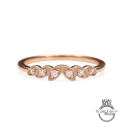 A rose gold ring with a leaf-shaped design and small diamonds set in it.