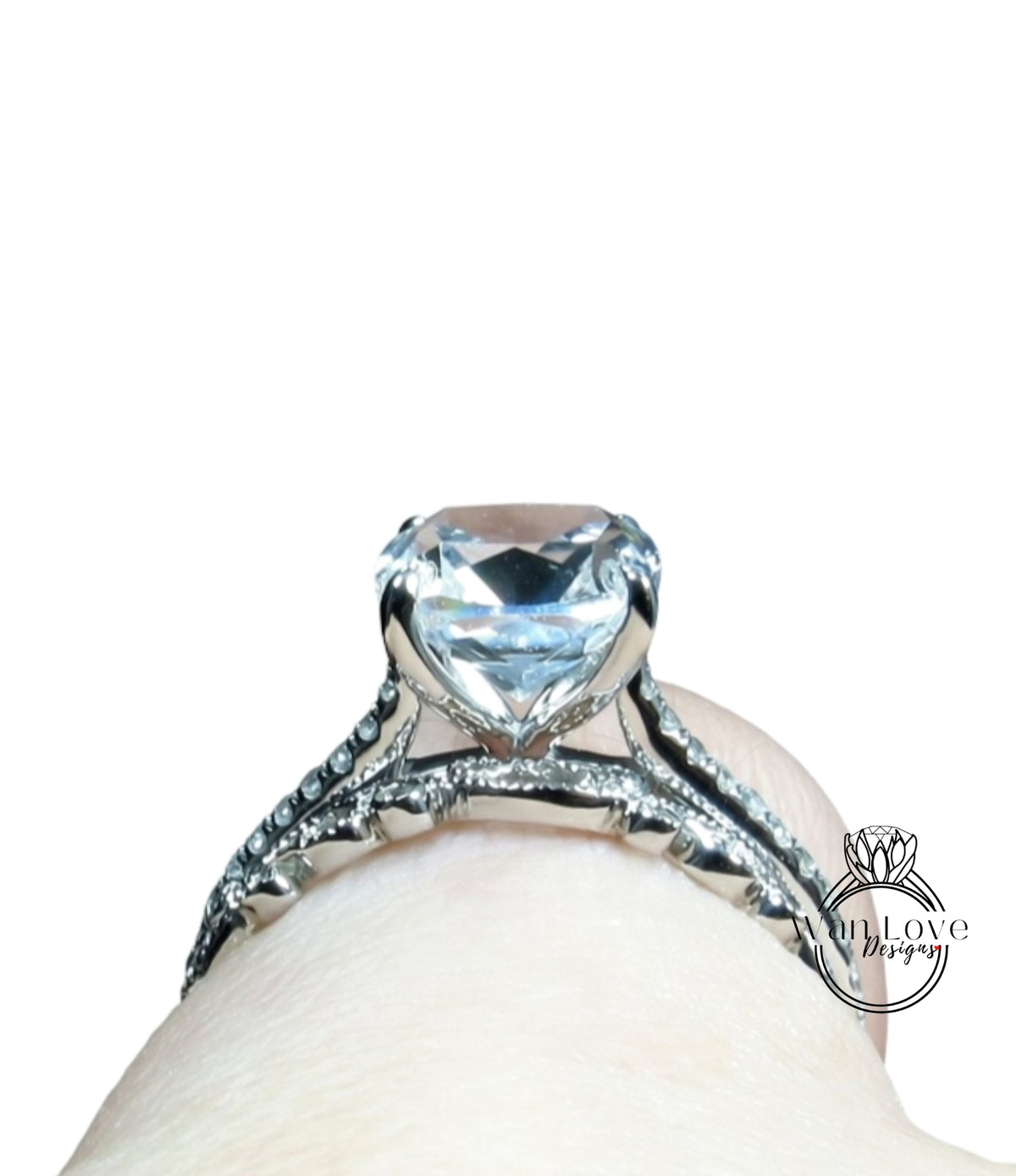 A close-up view of a diamond engagement ring on someone's hand, showcasing the large, clear gemstone set in a silver band.