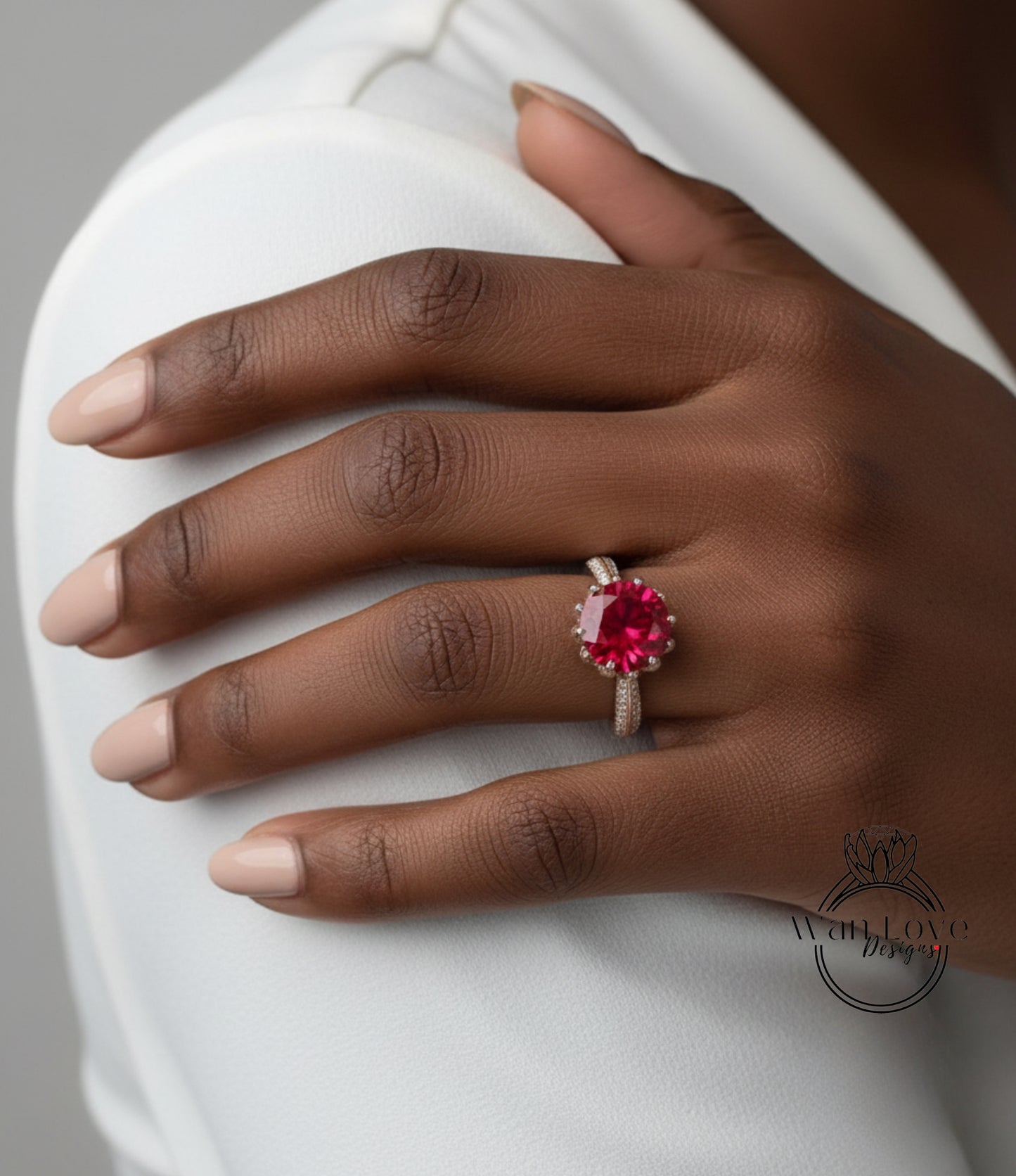 A close-up of a person's hand wearing a ring with a large, vibrant red gemstone.