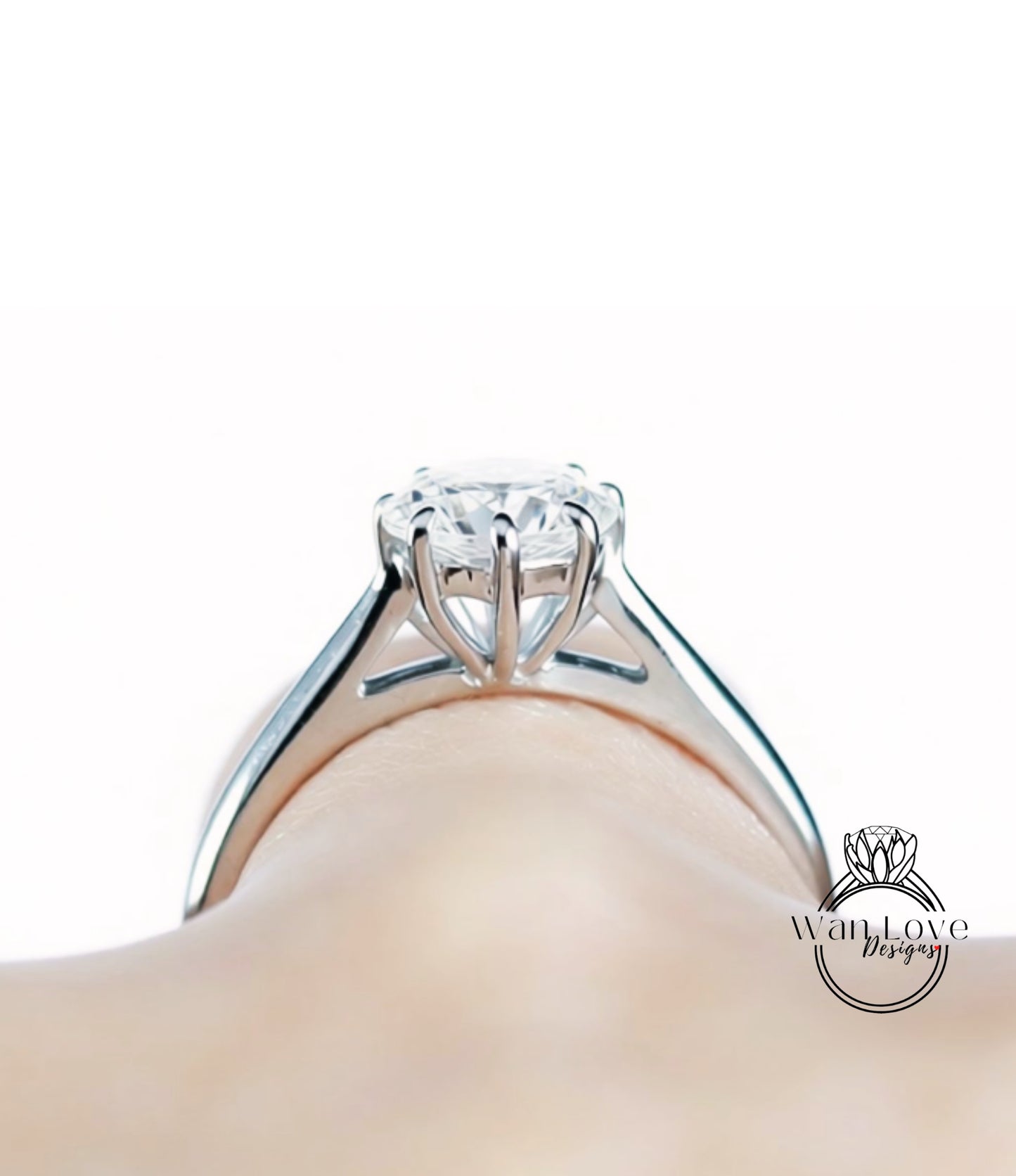 A close-up view of a diamond engagement ring on a person's hand.