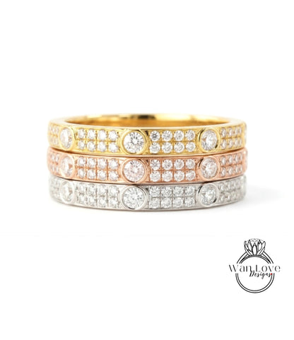 A ring with three concentric bands of diamonds in various colors, including gold, silver, and pink.
