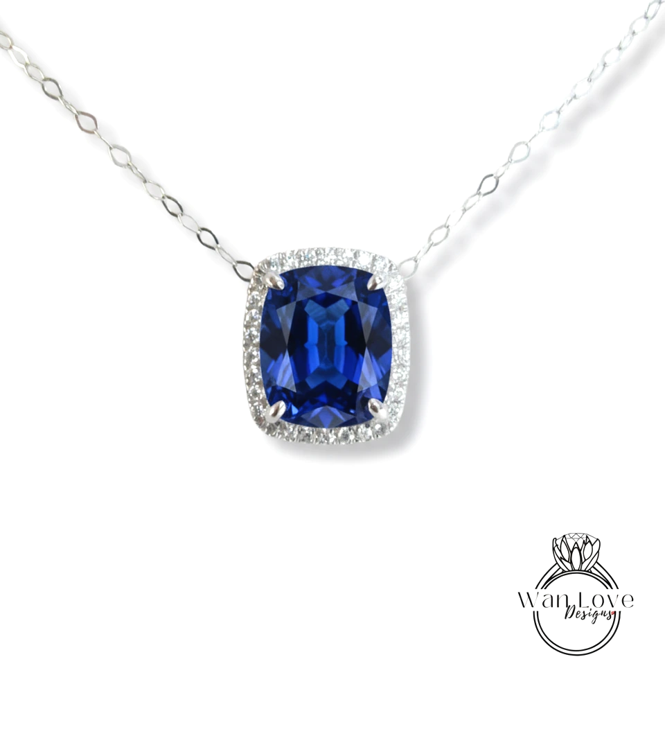 A necklace with a large blue gemstone, likely a sapphire, set in a halo of smaller diamonds.