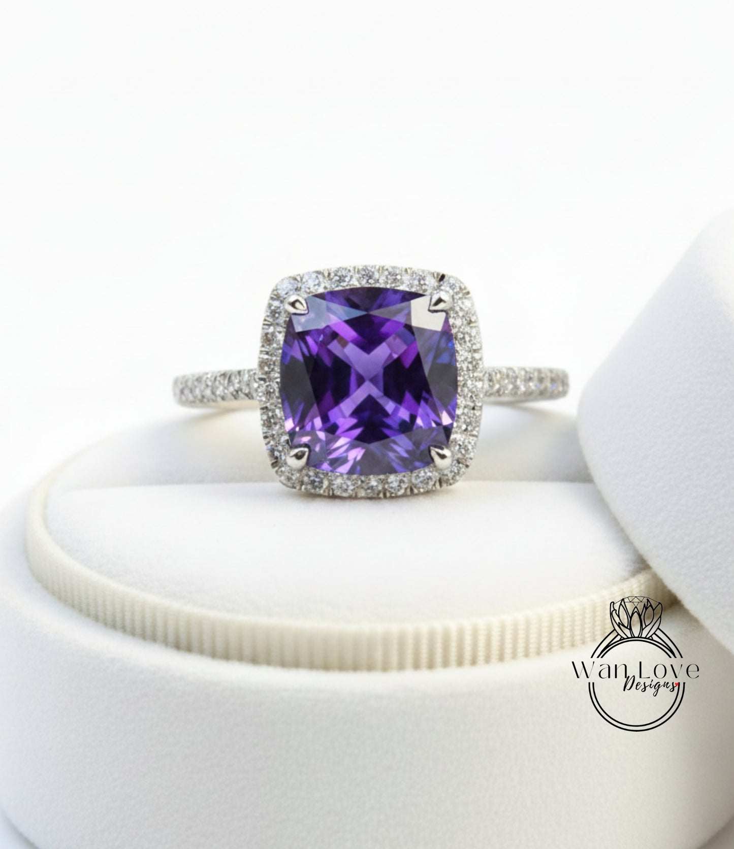 A ring with a large purple gemstone set in a halo of smaller diamonds, displayed on a white background.