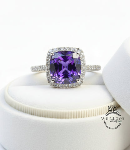 A ring with a large purple gemstone set in a halo of smaller diamonds, displayed on a white background.