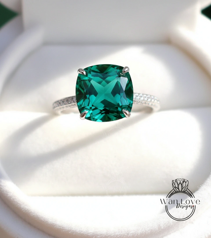 A large, square-cut green gemstone, possibly a diamond, set in a silver ring.