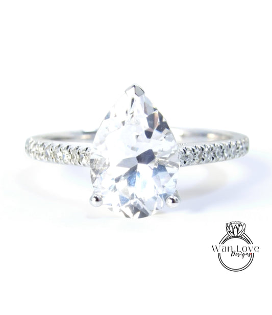 A close-up of a diamond engagement ring with a large, clear gemstone set in a silver band.