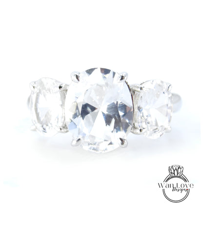 A close-up image of a diamond ring with a large oval-shaped diamond in the center, surrounded by smaller diamonds.