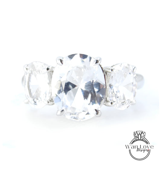 A close-up image of a diamond ring with a large oval-shaped diamond in the center, surrounded by smaller diamonds.