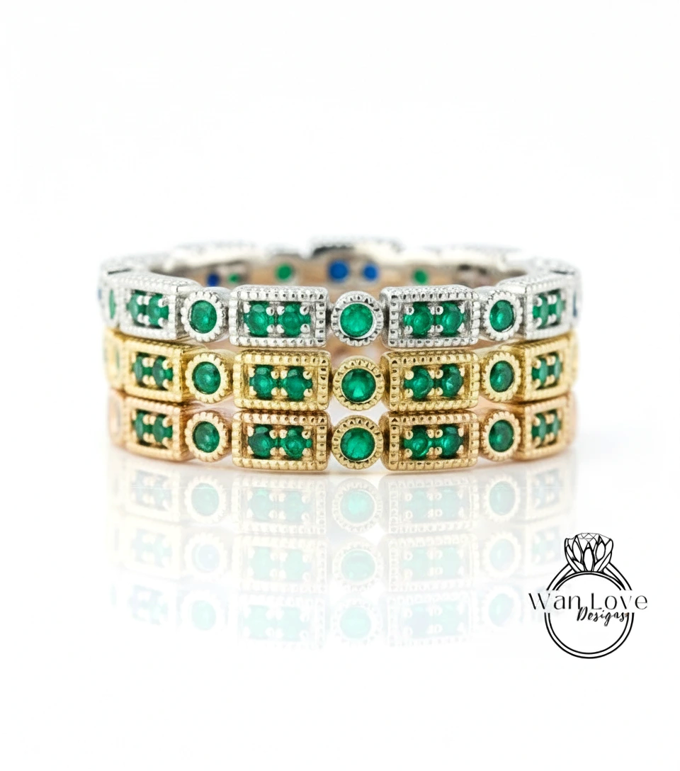 A stack of three rings with green gemstones set in gold and silver.