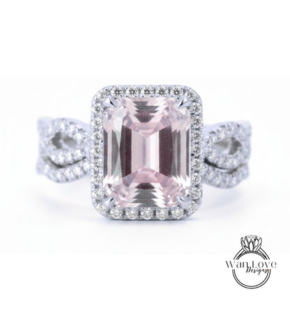 A large, pink gemstone ring with a halo of smaller diamonds around it, set in a silver band.