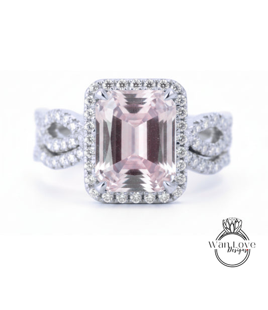 A large, pink gemstone ring with a halo of smaller diamonds around it, set in a silver band.