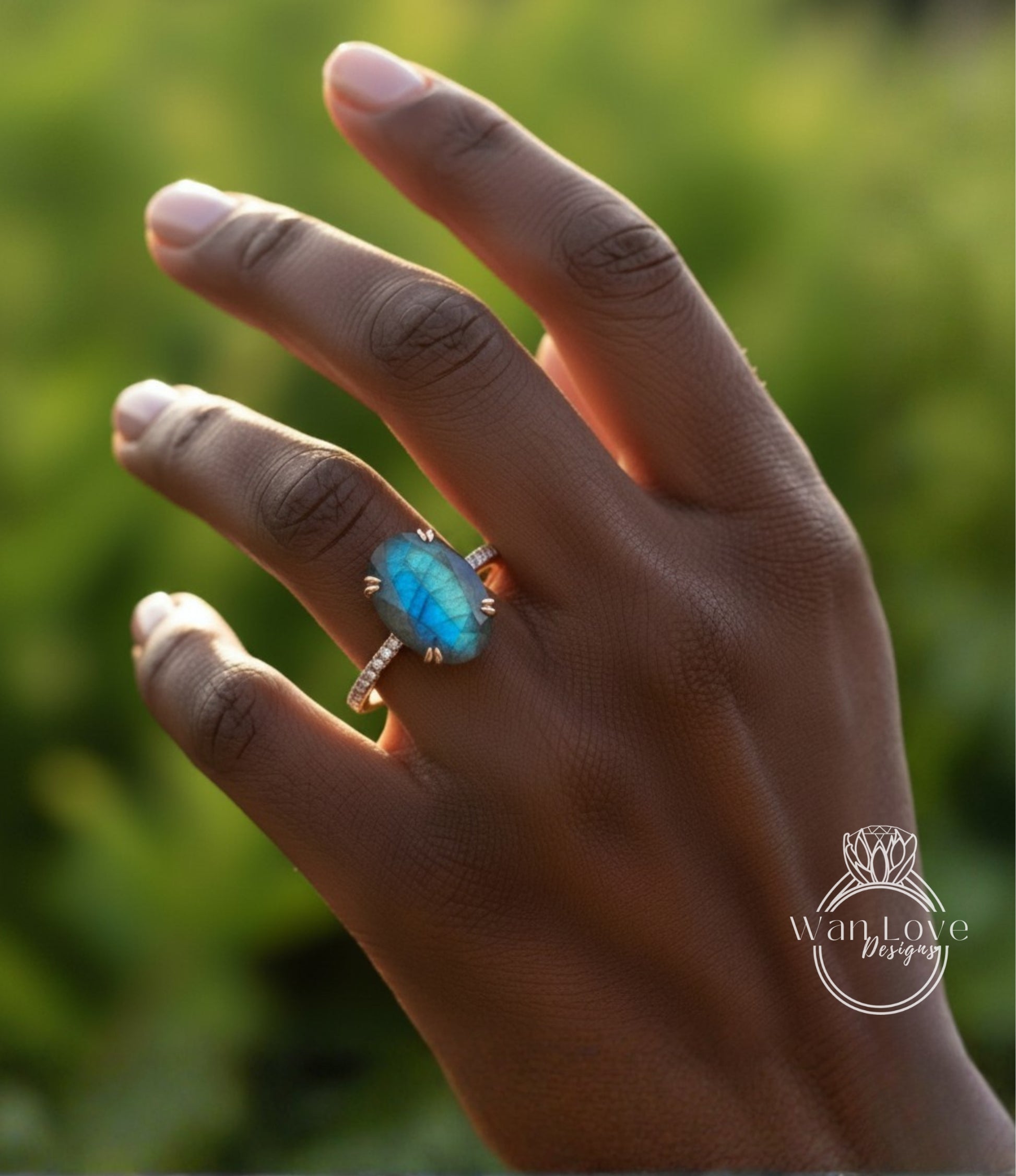 A close-up of a hand wearing a ring with a blue gemstone, set against a blurred green background.