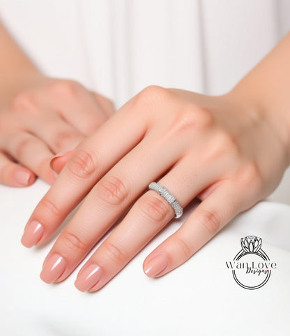 A close-up of a person's hand wearing a diamond ring on the ring finger.