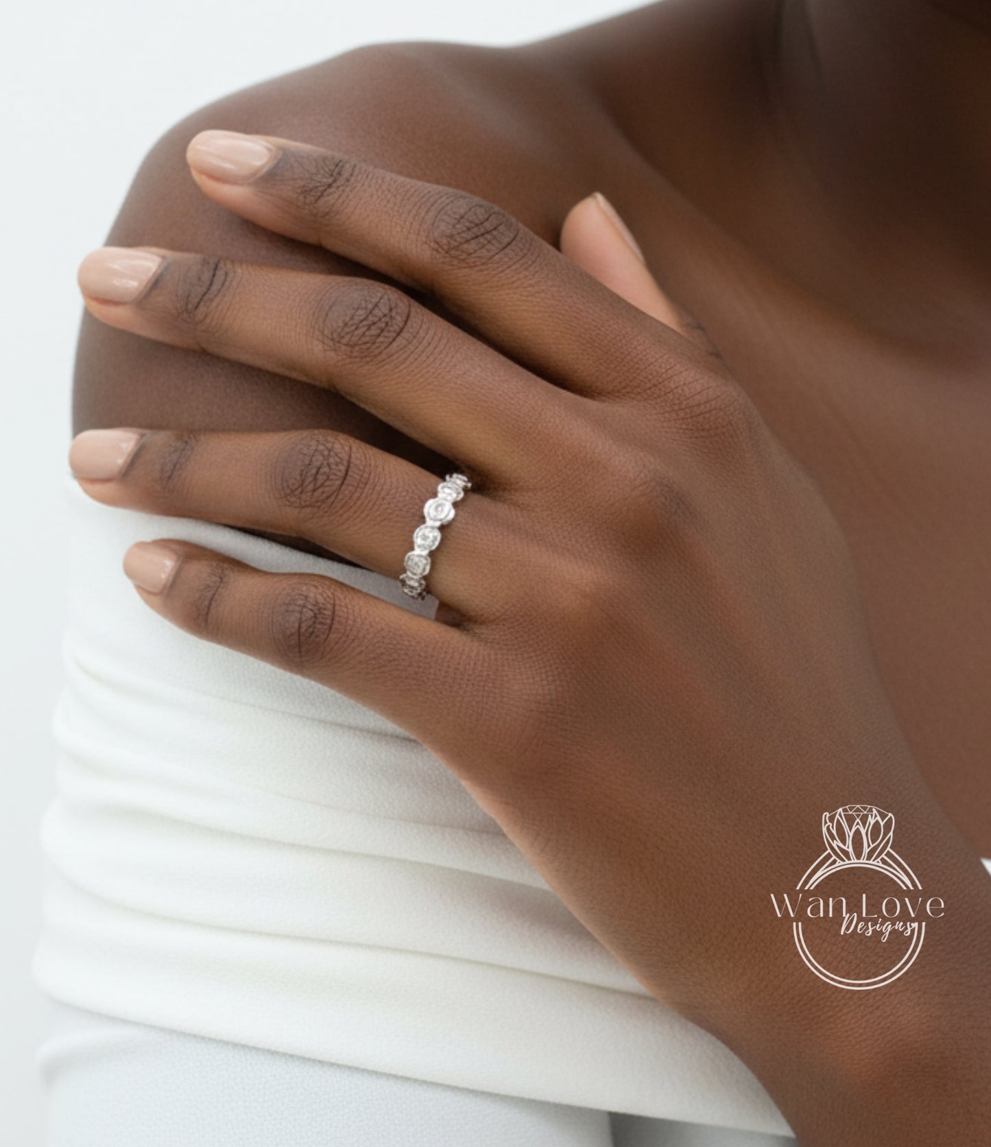 A close-up of a person's hand wearing a diamond ring on the ring finger.
