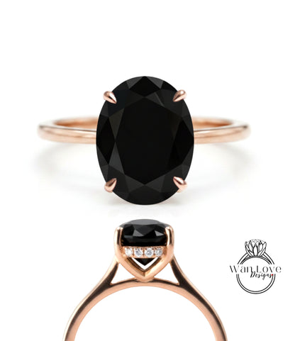 a rose gold ring with a large oval-shaped black gemstone, which appears to be a diamond.