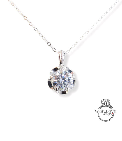 A close-up view of a delicate necklace with a large, brilliant-cut diamond pendant hanging from a chain.