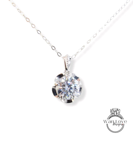A close-up view of a delicate necklace with a large, brilliant-cut diamond pendant hanging from a chain.