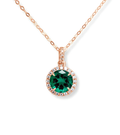 A necklace with a large, green gemstone pendant surrounded by smaller diamonds.