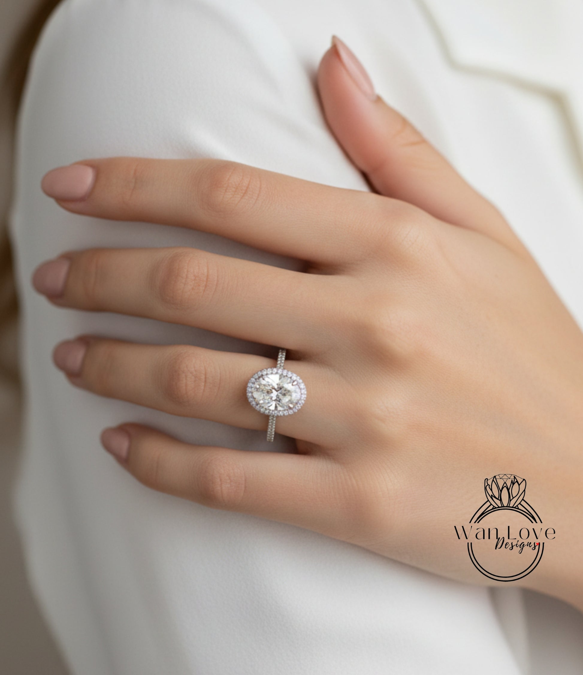 A close-up of a person's hand wearing a diamond engagement ring.