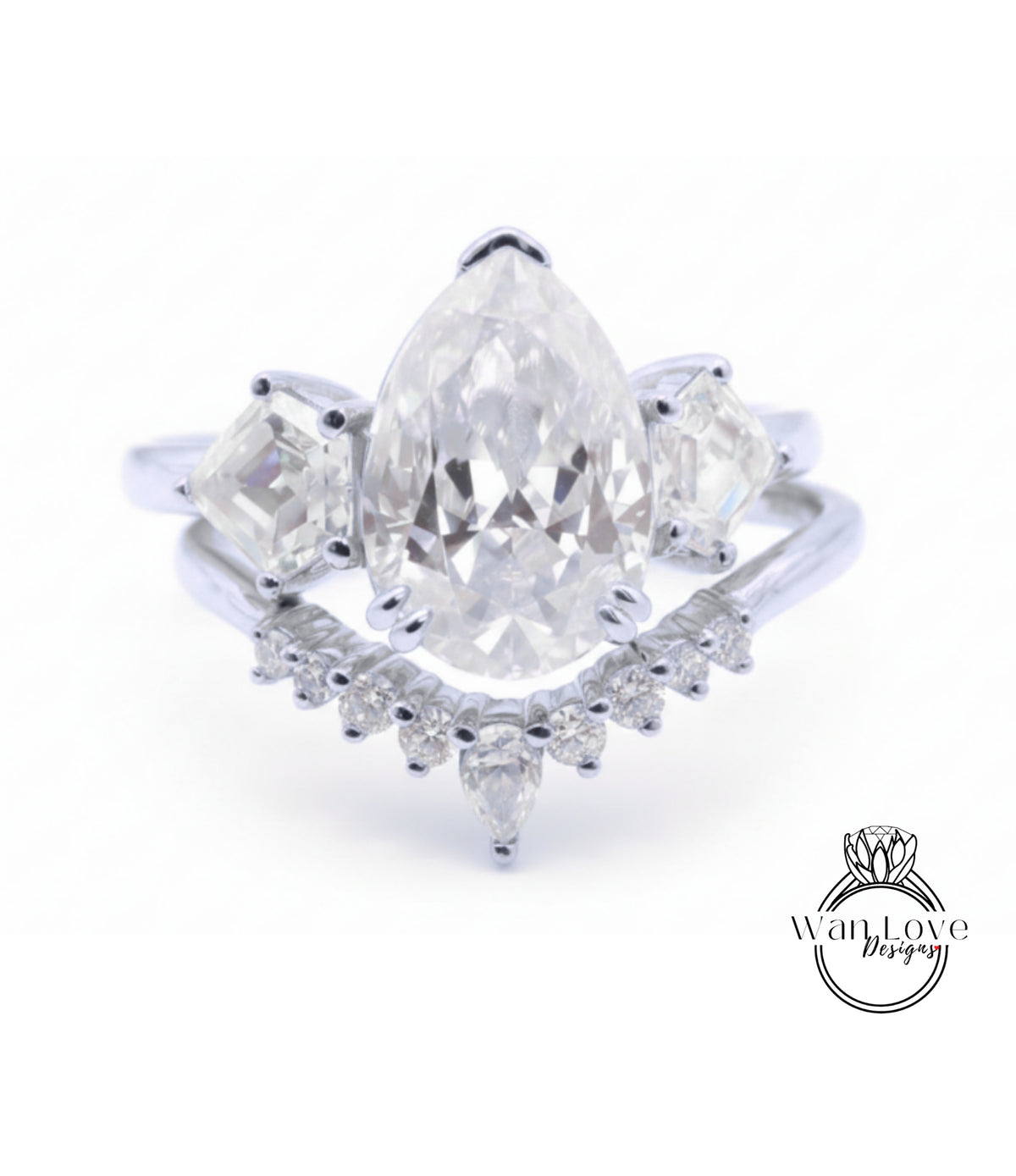 A close-up image of a diamond engagement ring with a large pear-shaped diamond at the center, surrounded by smaller diamonds on either side.