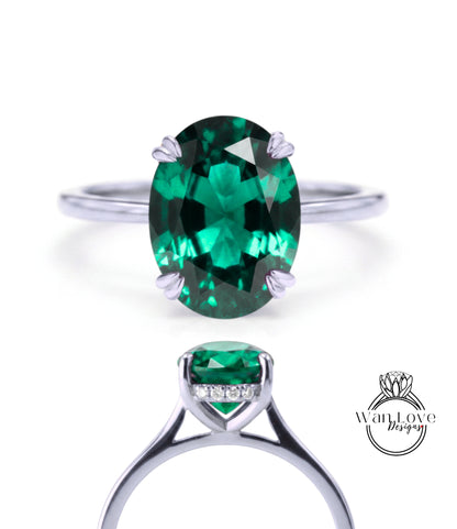 a silver ring with a large oval-shaped green gemstone, which appears to be a sapphire.