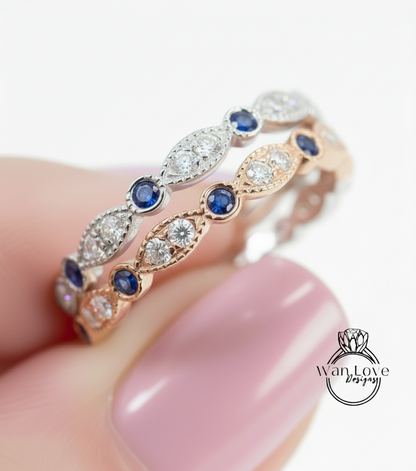 A close-up of a person's hand wearing a gold and silver ring with blue and white gemstones.