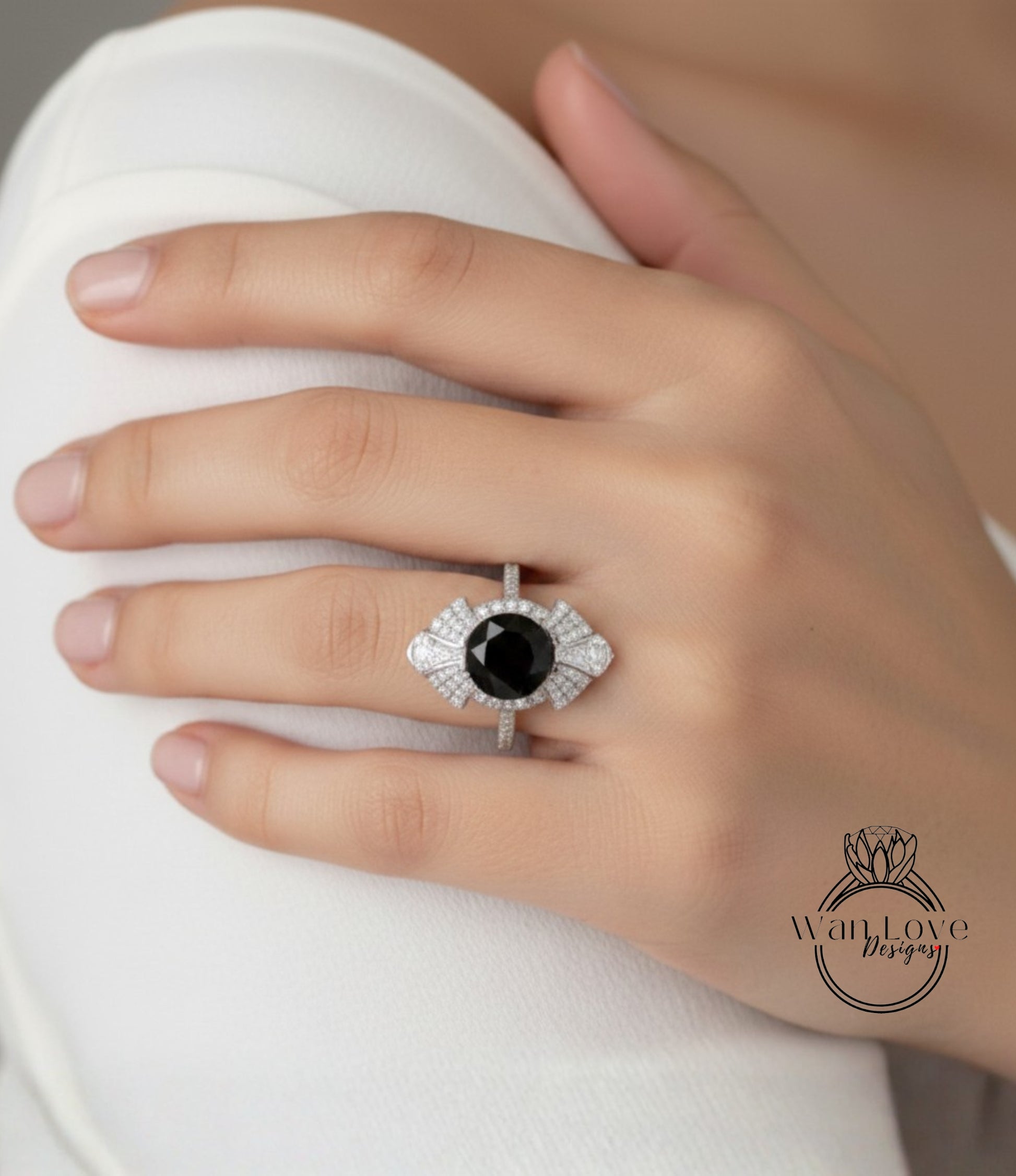 A close-up of a hand wearing a large, ornate ring with a black gemstone.