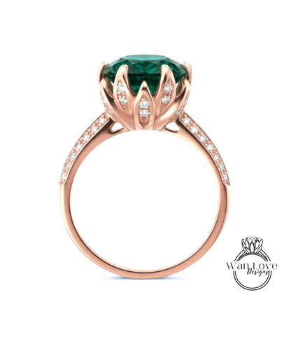 A rose gold ring with a large green gemstone, likely a diamond, set in a decorative flower-like design.